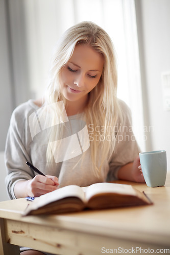 Image of Coffee, relax and woman writing in a book at home for idea, planning or creative, research or diary. Notebook, education and female student in a house with tea while brainstorming homework assignment