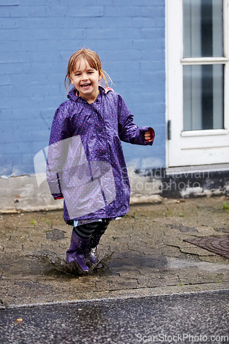 Image of Child, portrait and splash in mud puddle in raincoat for winter fun, explore city or cold weather happy. Young girl, excited and water on holiday vacation break for wet game or joy, surprise as kid