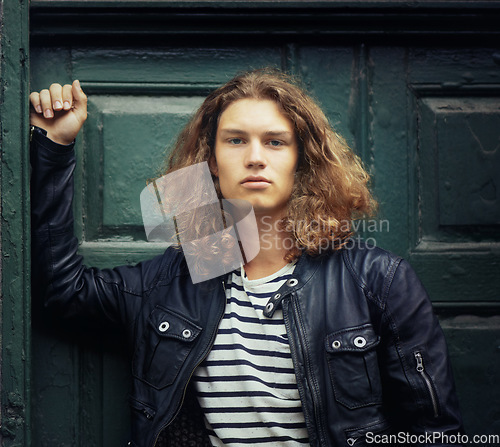 Image of Man, portrait and serious outdoor for fashion, urban style and edgy outfit with confidence and pride. Person, face and young model with casual jacket, long hairstyle and stylish with calm expression