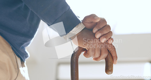 Image of Cane, hands and senior man in home living room for retirement in house. Walking stick, closeup and elderly person with a disability, crutch for injury and support, help for health and osteoporosis