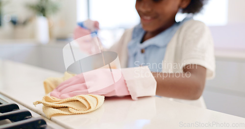 Image of Happy girl, hands and cleaning table for housekeeping, hygiene or disinfection in chores at home. Closeup of female person, child or kid wipe surface, furniture or kitchen in bacteria or germ removal