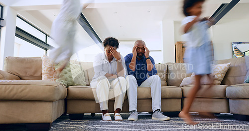 Image of Parents, stress and headache from children in home with noise, energy or overwhelmed in living room. Hyper active, adhd and tired mother and father with burnout from kids running, games or chaos