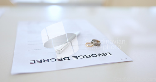 Image of Divorce, contract and pen with wedding in office for signature, decision and break up of marriage. Closeup, document or legal paperwork and rings with trouble, problem or conflict in relationship