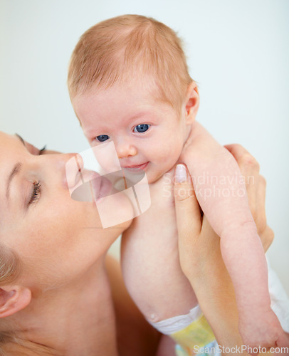 Image of Mother, family and kiss baby with love for trust, care support and health wellness for parent happiness. Woman, smile or cute newborn with blonde hair, blue eyes or gratitude connect or mama bonding