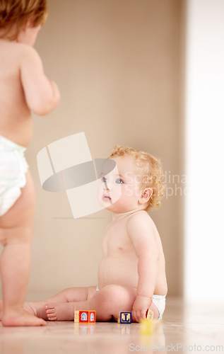 Image of Baby, siblings and building blocks on a a floor for learning, playing or bonding in a nursery room together. Family, fun and curious children with toys for child development, coordination or color