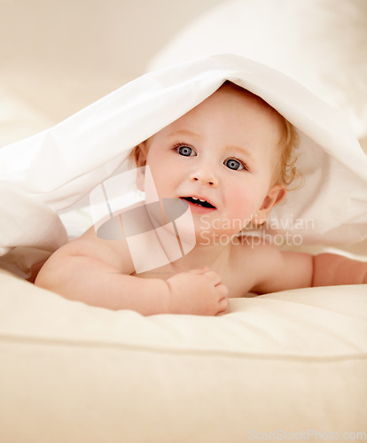 Image of Happy, face and baby on a bed with blanket for playing, games or fun in a nursery room. Learning, child development and curious boy kid in a bedroom with sheet cover while lying, resting or relax