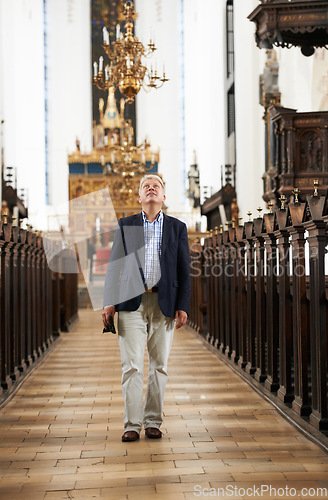 Image of Walking, aisle and elderly man in a church for sightseeing on a weekend trip, vacation or holiday. Grace, religion and holy senior male person in retirement in a worship cathedral in the city.