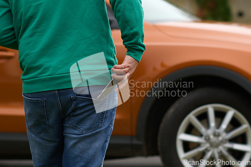 Image of man taking photos on a smartphone of a car preparing for sale