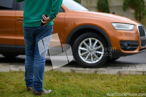 Image of man taking photos on a smartphone of a car preparing for sale