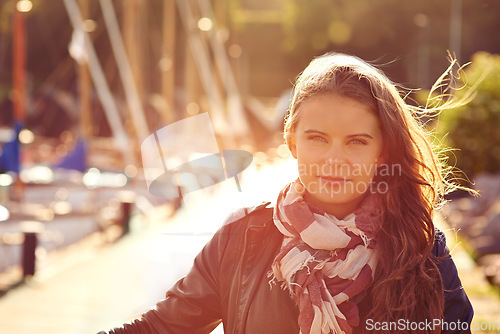 Image of Portrait, fashion in summer and a woman in the harbor for travel, freedom or adventure with flare. Face, wind and style with a confident young person outdoor in a dock or shipyard for trendy clothing