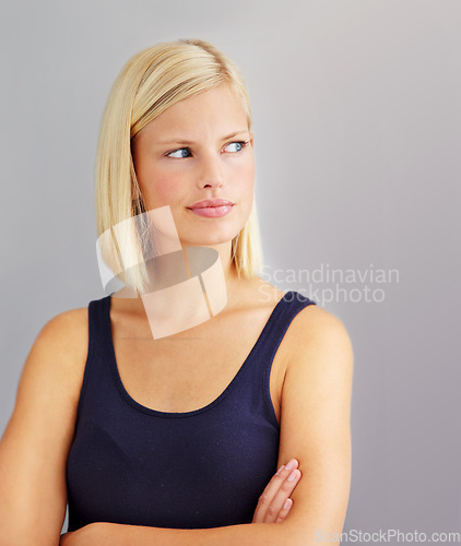Image of Angry, frustrated and woman with arms folded, cross and sad isolated on a gray studio background. Thinking, depression and blonde person annoyed at fail, mistake or anxiety, doubt and body language