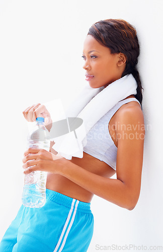 Image of Black woman, fitness and water with thinking and bottle from sport, workout and training in studio. Leaning, healthy and African female athlete with wellness and drink after gym with white background