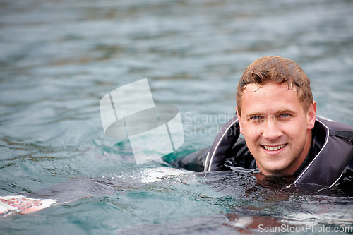 Image of Man, waterski and portrait in lake, happy and outdoor waiting for tow with fitness, extreme sports or exercise. Person, smile and river in nature, float and swimming for health with summer training