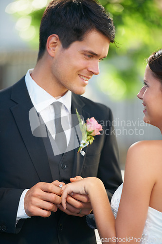 Image of Bride, groom and wedding ring exchange outdoor with love, care and excited for commitment, union or trust. Smile, happy and couple outside for marriage ceremony with support, security and promise