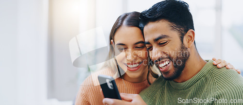 Image of Love, hug and happy couple with phone in a house for social media, streaming or checking meme in their home together. Smartphone, app and people smile in a living room for funny gif, text or chat