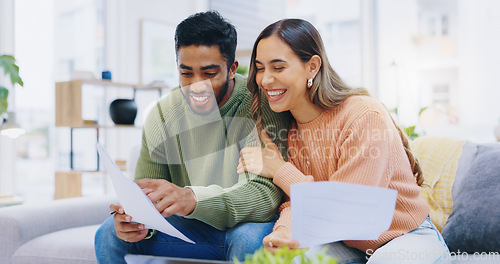 Image of Couple, tax documents and happy on sofa with reading, review and compliance for financial freedom in home. Man, woman and smile together for results, feedback and credit score with paperwork on couch