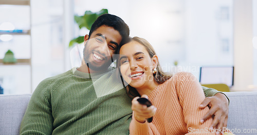 Image of Couple, watching tv and remote on living room couch with smile, hug or relax with click for choice, show or film. Man, woman and happy together for embrace, movie or streaming on lounge sofa in home