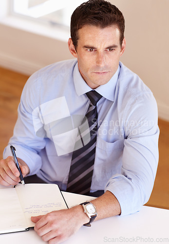 Image of Businessman at desk thinking, writing and notes for market research, business plan and insight at startup. Office, notebook and man with schedule, agenda or to do list in book with ideas for project.