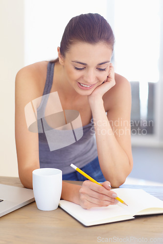 Image of Coffee, notebook and a woman writing in the kitchen of her home in the morning for education or journaling. Tea, diary and a happy young person in her apartment for planning, research or study