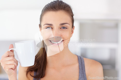 Image of Portrait, smile and young woman drinking coffee in the kitchen of her home to wake up in the morning. Face, wellness and time off with a happy person in an apartment to enjoy a warm caffeine beverage