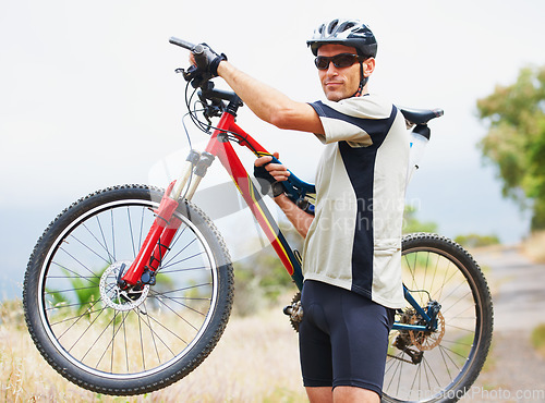 Image of Portrait, bicycle and fitness with a man in the mountains for cardio training, recreation or summer hobby. Sports, cycling and freedom with a confident young athlete outdoor for eco friendly exercise