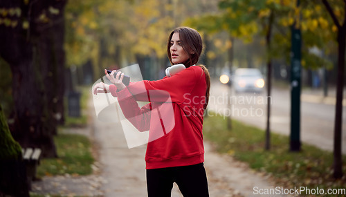 Image of Athletic young woman taking a breath and relaxing after jogging and stretching. Woman Training and Workout Exercises On Street.