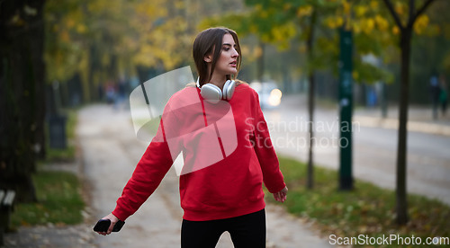 Image of Athletic young woman taking a breath and relaxing after jogging and stretching. Woman Training and Workout Exercises On Street.