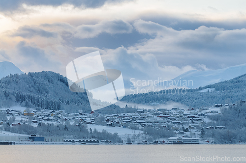 Image of Tranquil Winter Morning Over a Snow-Covered Village by the Sea