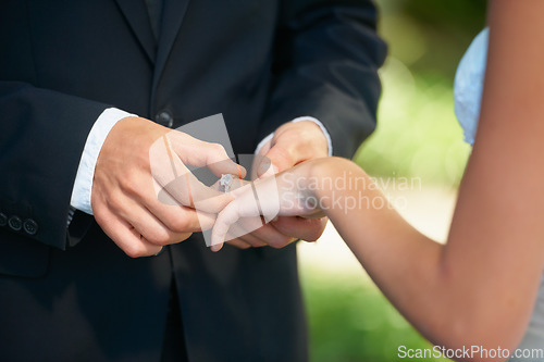 Image of Couple, hands and wedding ring for proposal, commitment or promise in love, care or trust and support at ceremony. Closeup of married man putting jewelry on bride for loyalty, marriage or engagement