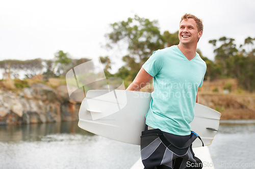 Image of Sports, happy and man by lake with wakeboard for surfing, exercise and recreation hobby outdoors. Fitness, extreme sport and excited person with board for water skiing for freedom, adventure and fun