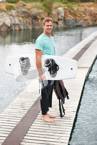 Image of Sports, portrait and man by lake with wakeboard for surfing, exercise and recreation hobby outdoors. Fitness, extreme sport and person with board for water skiing for freedom, adventure and fun