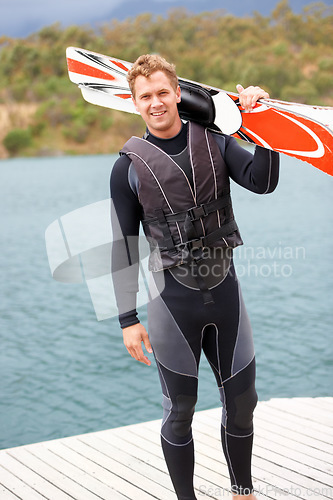 Image of Water ski, portrait and man by lake with wakeboard for surfing, exercise and recreation hobby outdoors. Fitness, extreme sports and excited person with board for skiing for freedom, adventure and fun