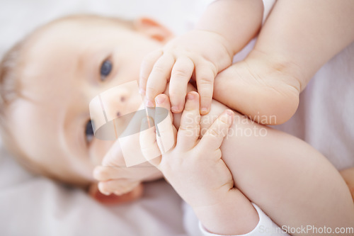 Image of Home, bed and baby with feet playing to relax, resting and calm in nursery for sleeping or wake up in morning. Family, youth and closeup of newborn in bedroom for child development, fun and wellness