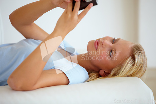 Image of Happy, cellphone or woman on a couch, smile or typing with internet, social media or website info. Person on a sofa, apartment or girl with a smartphone, chatting or texting with digital app or home