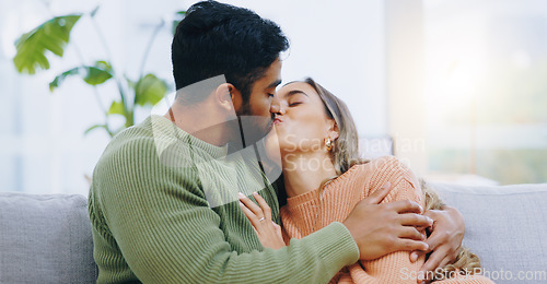 Image of Love, hug and couple kissing on a sofa with romance, bond and intimacy at home together. Passion, desire and people embrace in a living room with romance, moment or soulmate connection in a house