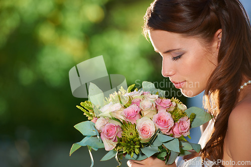 Image of Woman, smell and wedding rose bouquet with love, commitment and trust ceremony for marriage. Engagement, celebration and flowers for event in a park with a red floral plant and bride dress outdoor