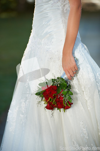 Image of Woman, hands and wedding red rose bouquet with love, commitment and trust ceremony for marriage. Engagement, celebration and flowers for event in a park with a floral plant and bride dress outdoor
