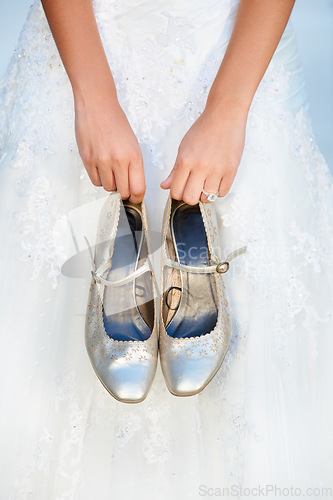 Image of Hands, wedding and closeup of a bride with shoes and dress for luxury, elegant and romantic event. Zoom of woman with silver, fashion and bridal heels and garments marriage ceremony or celebration.