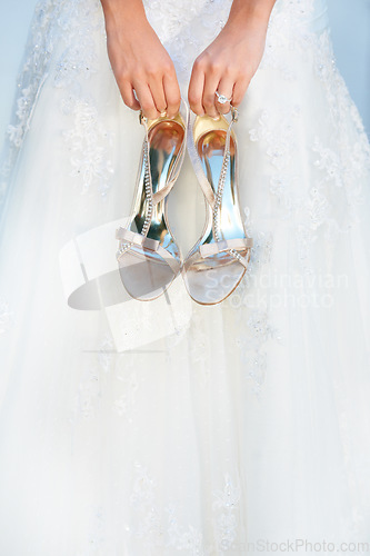 Image of Hands, wedding and closeup of a bride with shoes and dress for luxury, elegant and romantic event. Zoom of woman with silver, fashion and bridal heels and garments marriage ceremony or celebration.