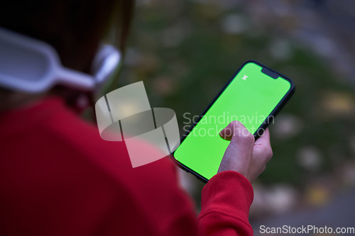 Image of Tired fitness woman after workout and use smartphone with green screen