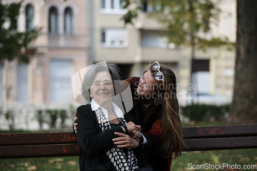 Image of Elderly old cute woman with Alzheimer's very happy and smiling when eldest daughter hugs and takes care of her