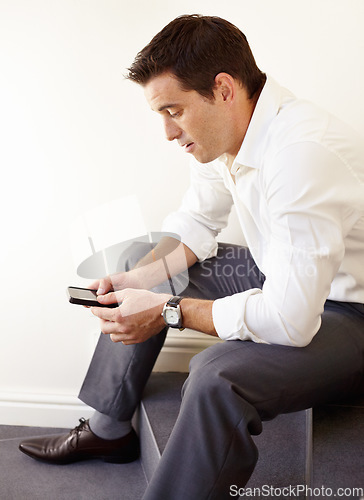 Image of Business man, phone and stairs in office for reading, thinking and trading with crypto on application. Entrepreneur, investor and check smartphone for stock market, social network or fintech on steps