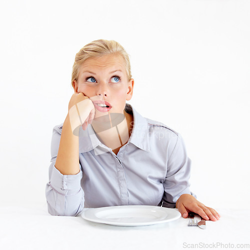 Image of Bored, hungry and woman with a plate in a studio with upset, frustrated and grumpy face. Angry, moody and young female person from Australia with dish and cutlery isolated by white background.