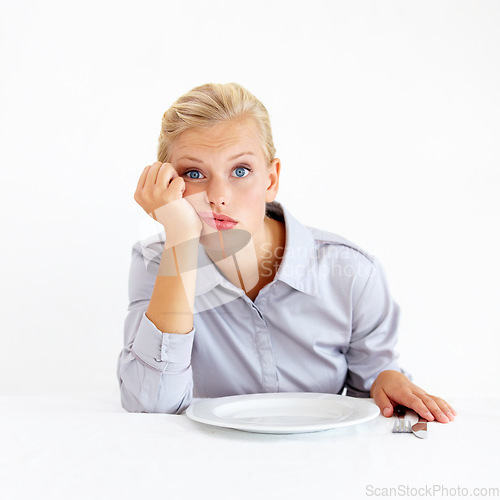 Image of Hungry, portrait and woman with a plate in a studio with upset, frustrated and grumpy face. Bored, moody and young female person from Australia with dish and cutlery isolated by white background.
