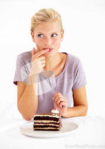 Image of Sneaky, cake and young woman in a studio cheating on healthy, wellness or weight loss diet. Yummy, sweet and female person from Australia eating a chocolate dessert isolated by white background.