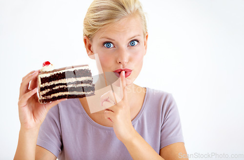 Image of Secret, cake and young woman in a studio cheating on healthy, wellness or weight loss diet. Yummy, sweet and female person from Australia eating a chocolate dessert isolated by white background.