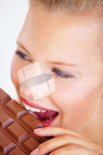 Image of Studio face, woman and eating chocolate slab bar, delicious snack or unhealthy junk food, dessert or sugar candy. Wellness craving, beauty skin and person bite sweets isolated on white background