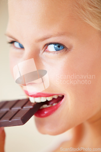 Image of Portrait, eating or happy woman bite chocolate bar, snack or junk food for wellness, stress relief or craving. Face headshot, delight or girl taste cacao slab, antioxidant benefits or diet cheat meal
