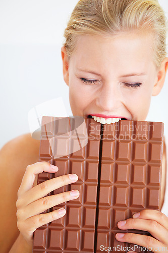 Image of Eating woman, hungry and bite chocolate bar, delicious snack or candy for studio food, dessert or sugar craving. Diet cheat meal calories, diabetes or girl hunger for cacao sweets on white background