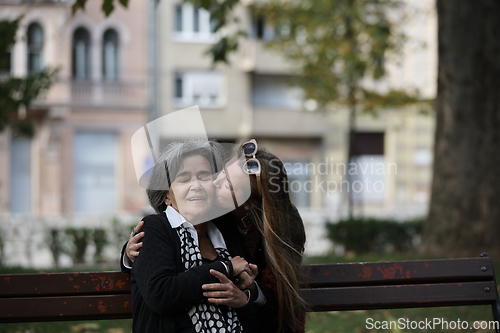 Image of Elderly old cute woman with Alzheimer's very happy and smiling when eldest daughter hugs and takes care of her